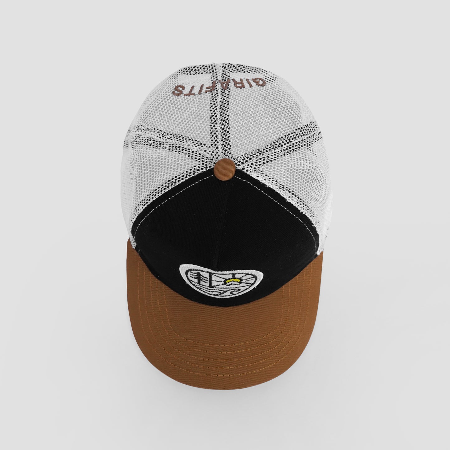 Baseball cap with brown brim, black visor, and white mesh back on a light gray background