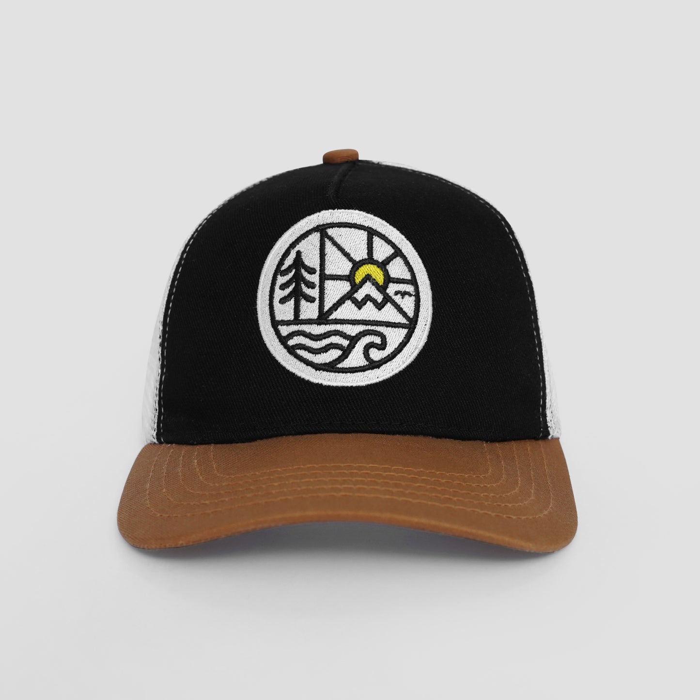Black and brown cap with a circular emblem featuring trees, a sun, and water on a light gray background.