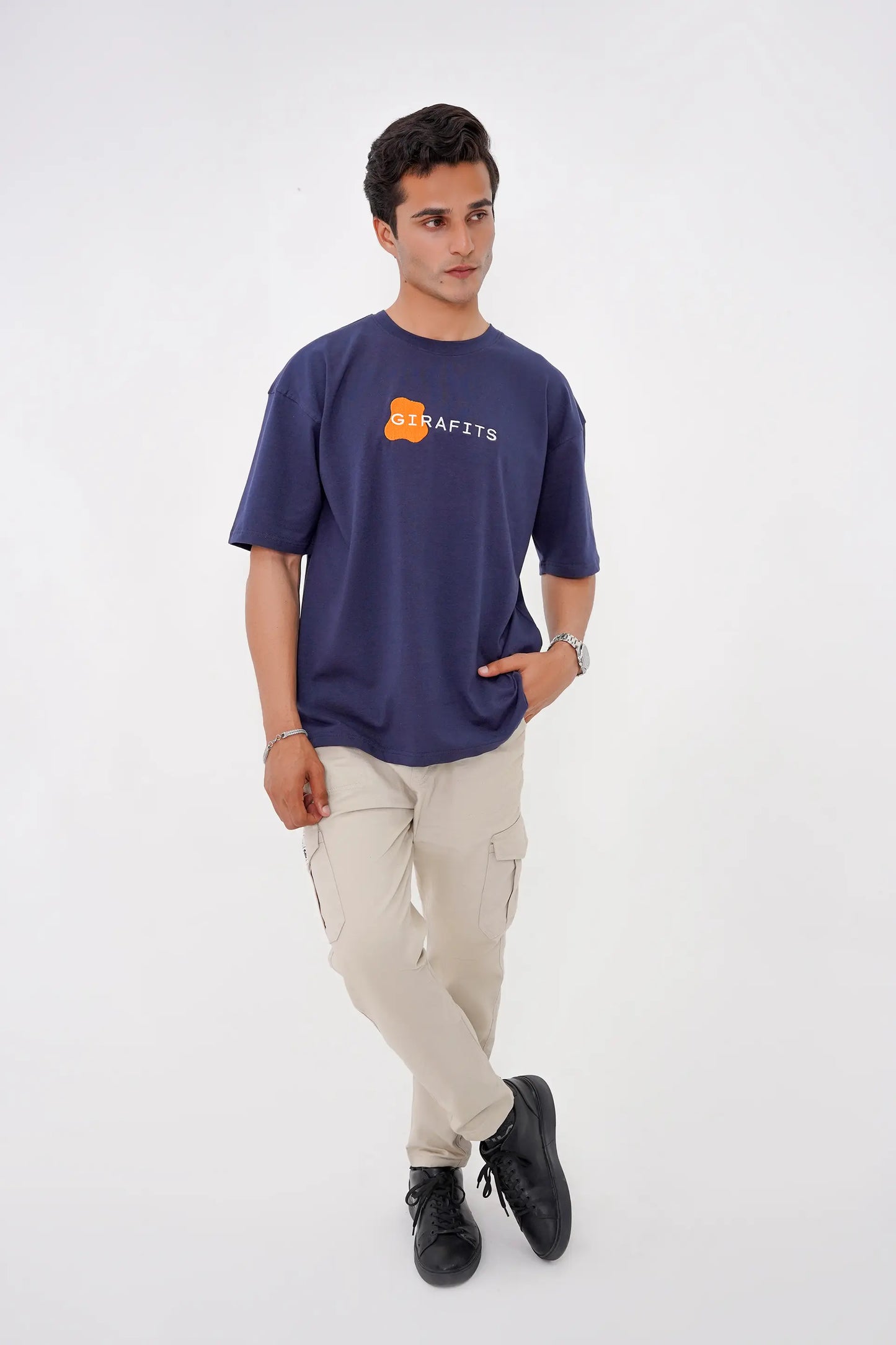 Man wearing a navy blue t-shirt with a logo on a white background