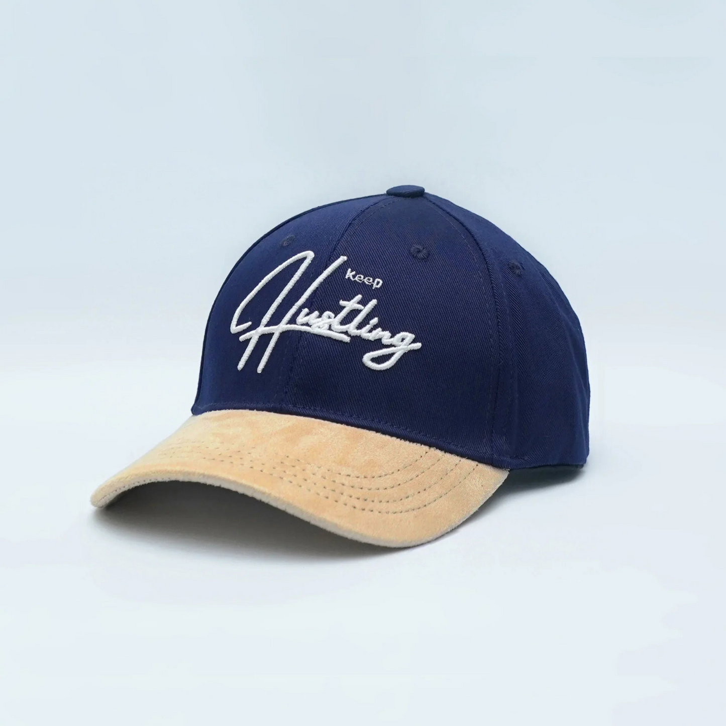 Indigo and camel baseball cap with 3D embroidered "Keep Hustling" text