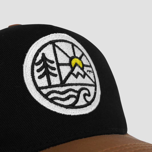 Black cap with a white embroidered logo featuring trees, mountains, and a sun on a light gray background
