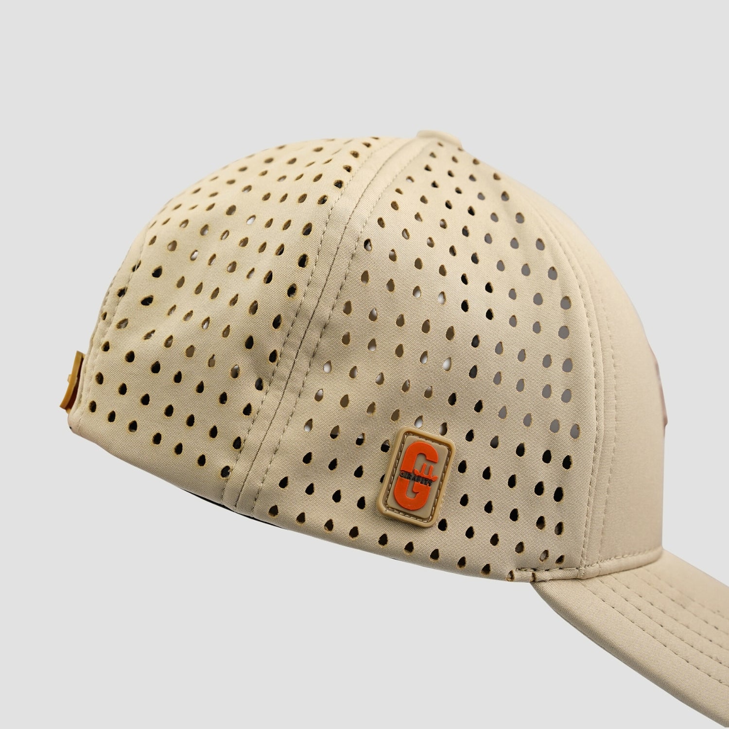 Beige cap with perforated design and a logo on a light gray background