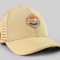 Beige cap with 'Adventure Awaits' patch on a gray background