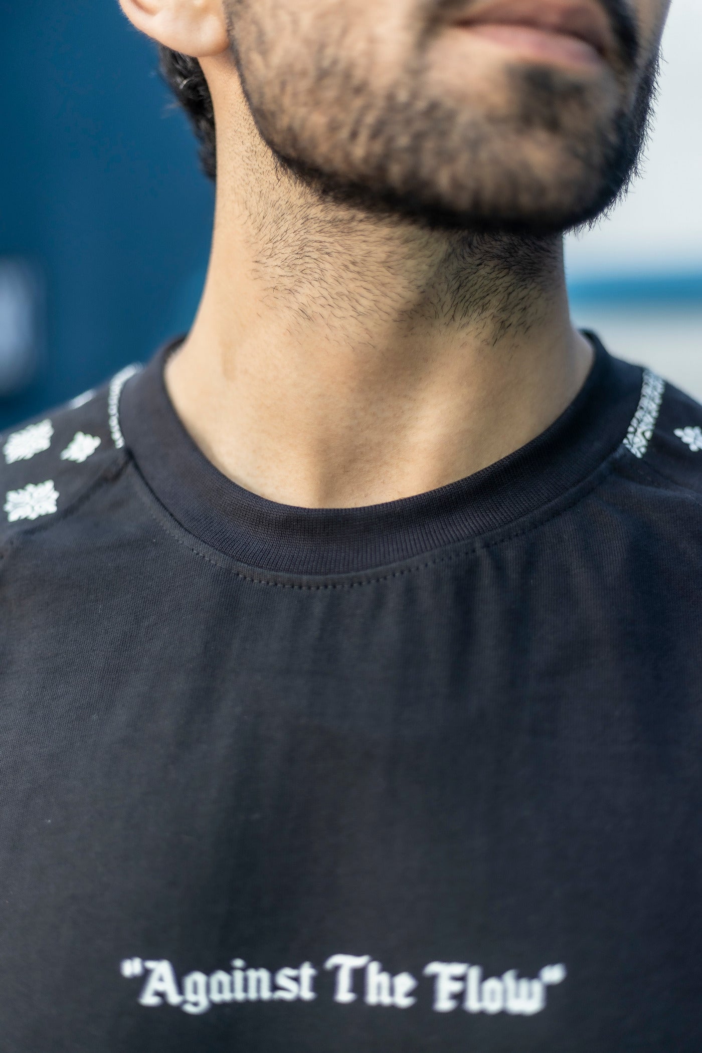 Breathable black oversized tee with sleeve graphics and Against The Flow print