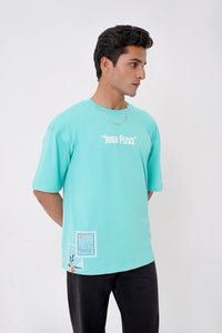 Man wearing a light green t-shirt with text and graphics on a white background