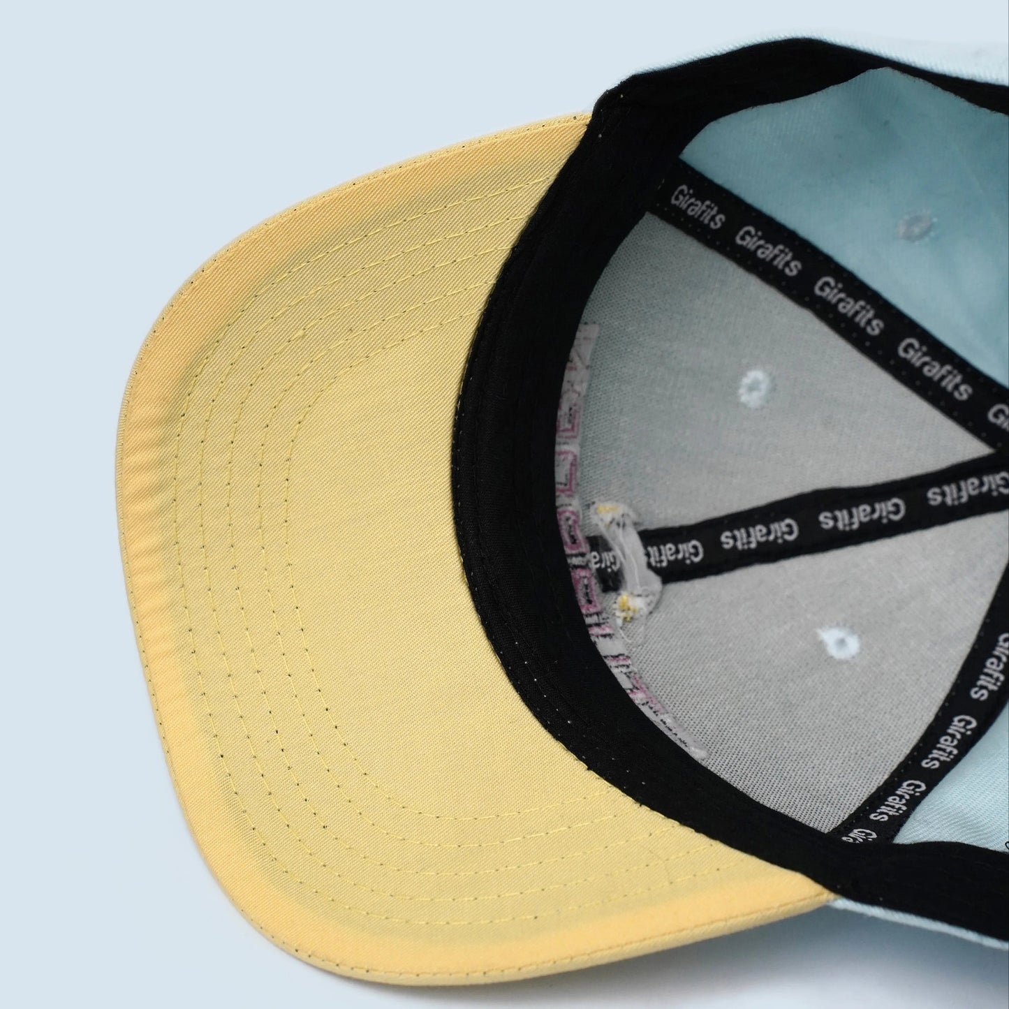 Sky blue and light yellow baseball cap with "Stubborn" text embroidery