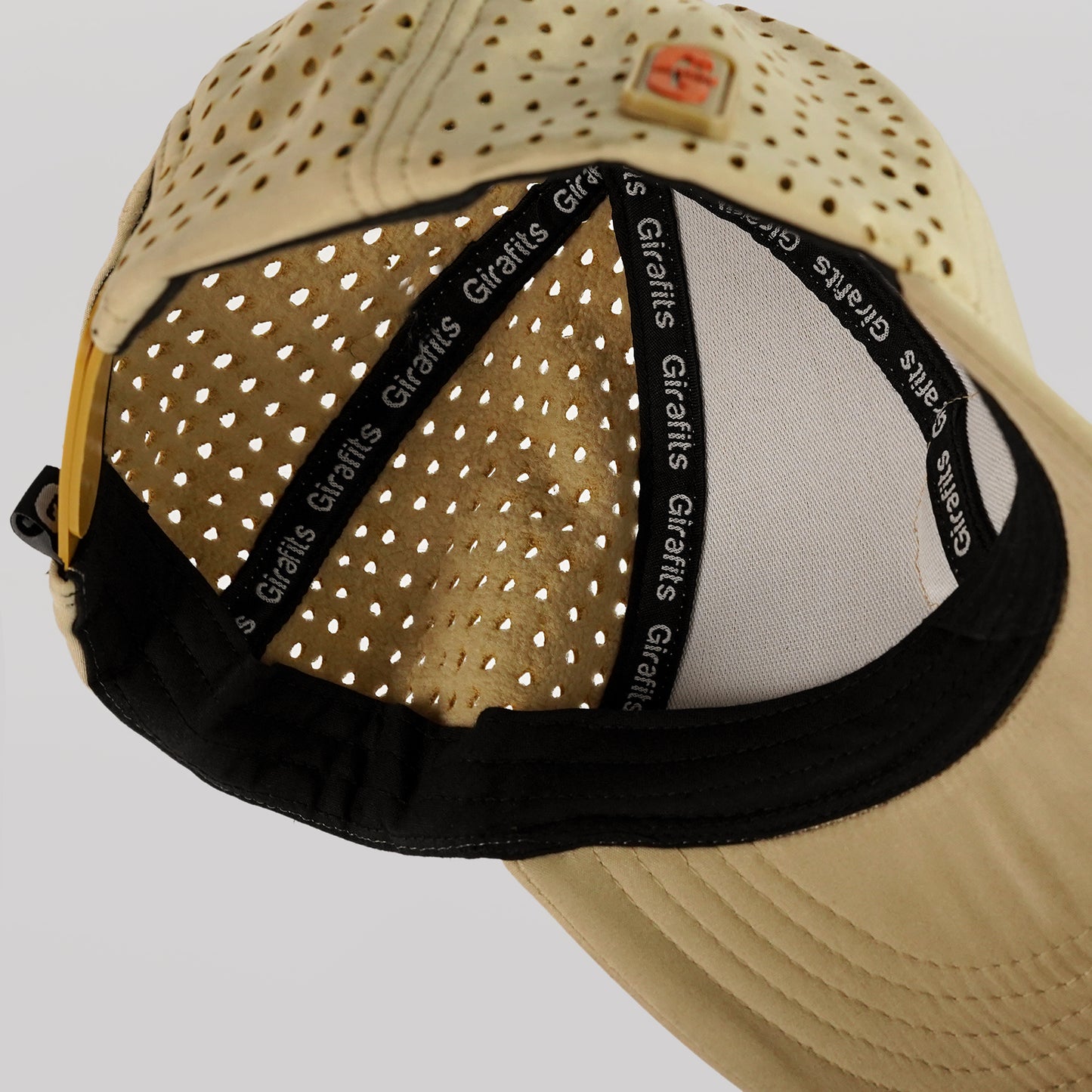 Beige cap with perforated design and black band featuring 'Girafits' branding on a light gray background.