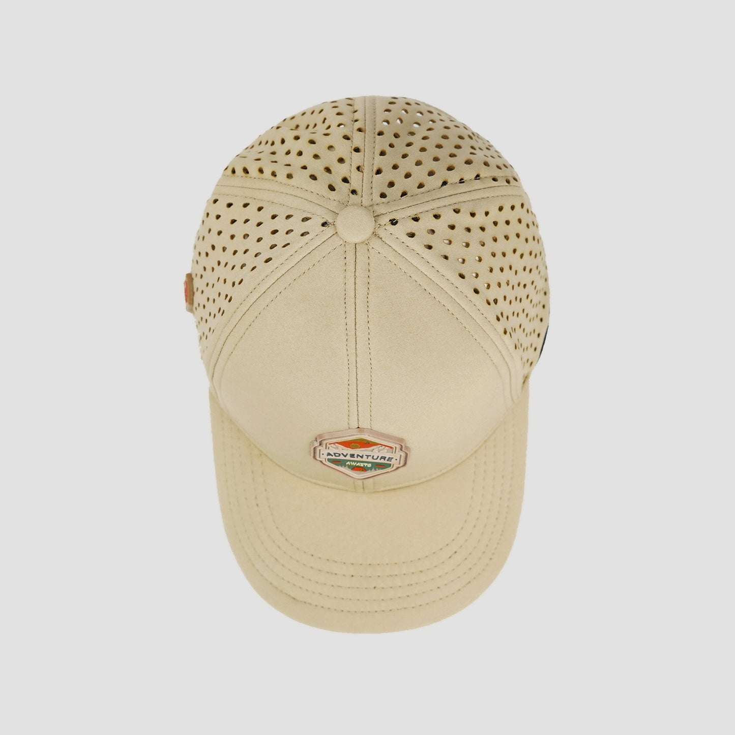 Beige cap with perforated design on a white background