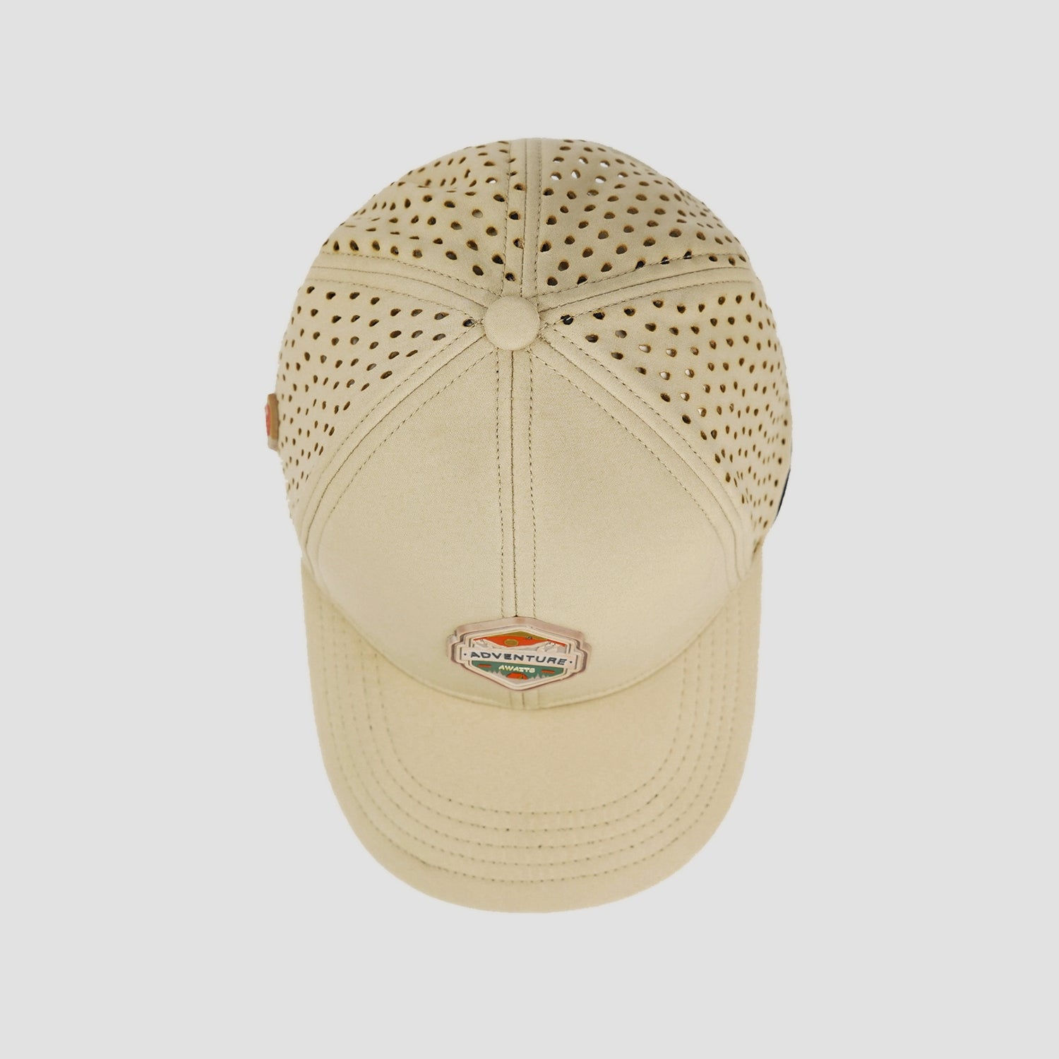 Beige cap with perforated design on a white background