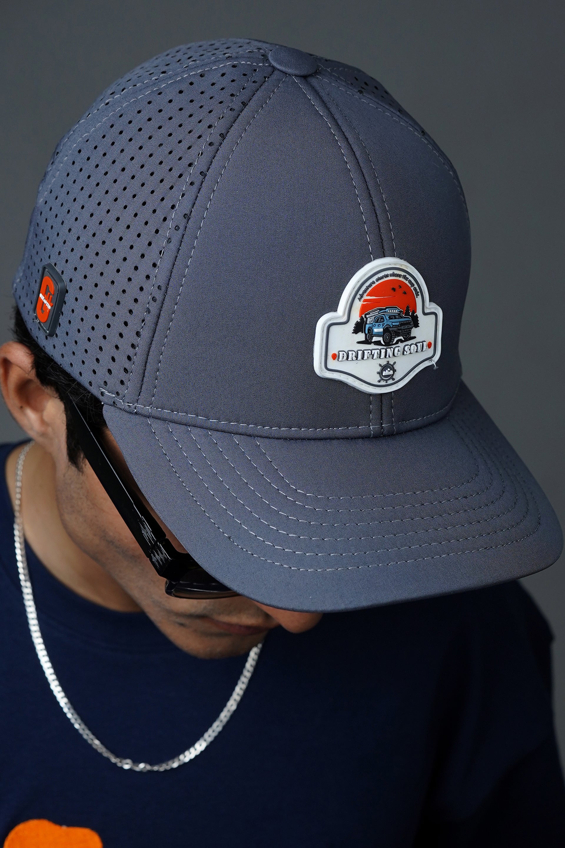 Gray softshell baseball cap with “Drifting Soul” design and laser-cut vents